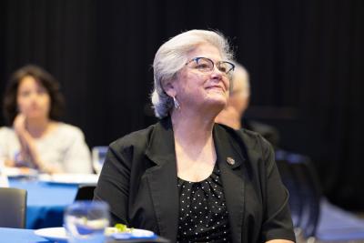 A woman smiles while seated at a table