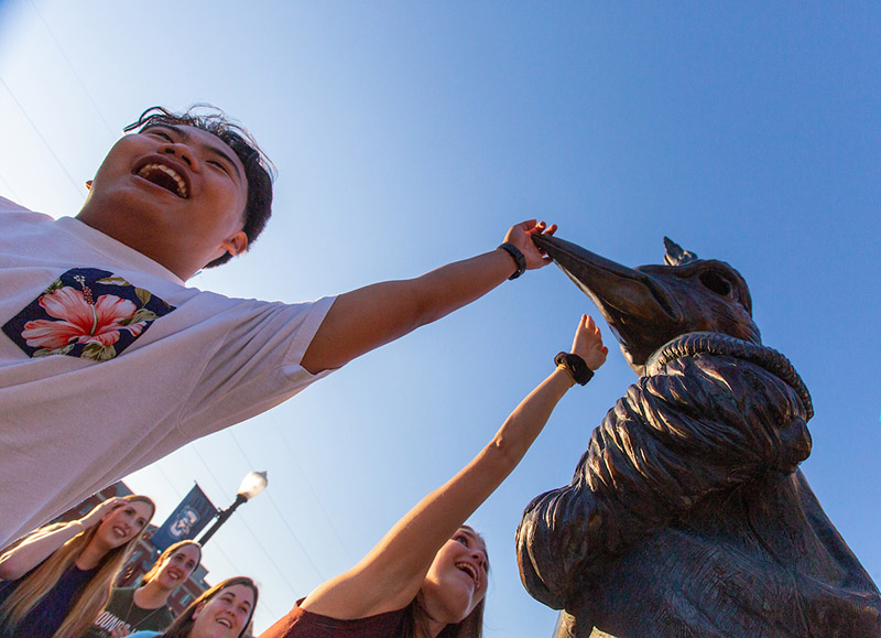 Students tap Billy's beak along the Mall for Welcome Week.