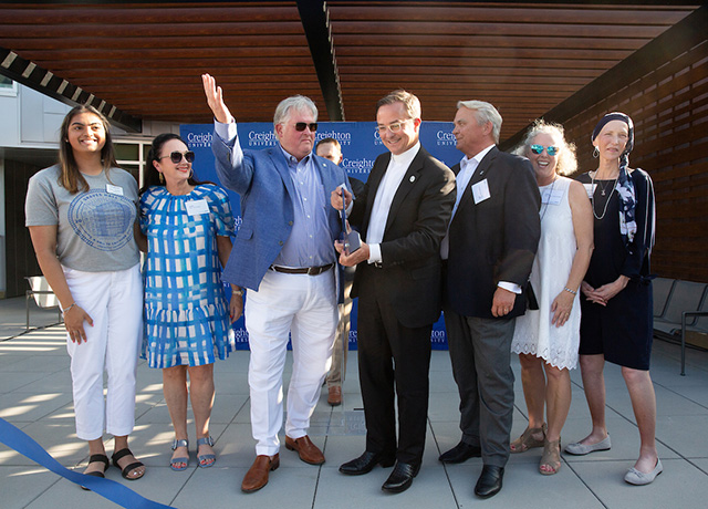 The Graves and Simpson families cut the ribbon, along with Fr. Henrickson.