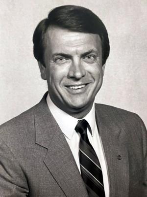 A black and white photo of a smiling man