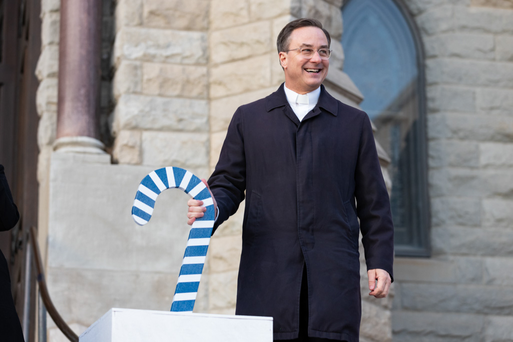 Creighton's president places his hand on a blue candy cane lever