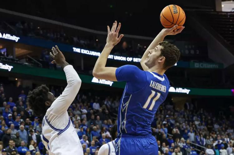 A player shoots a basketball with one hand