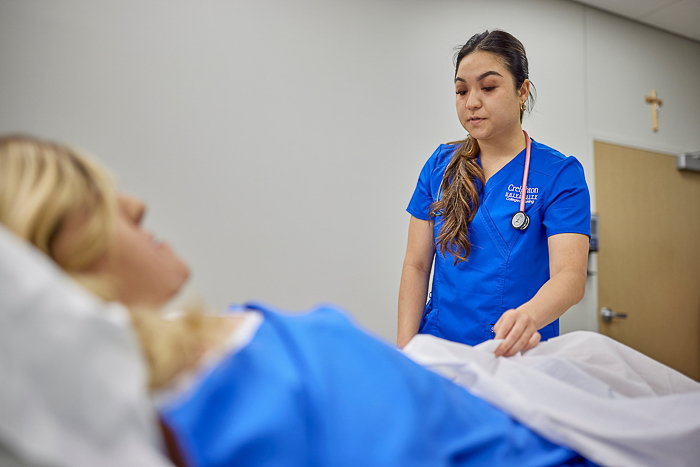 Creighton nurse interacts with a patient. Creighton nurse interacts with a patient.