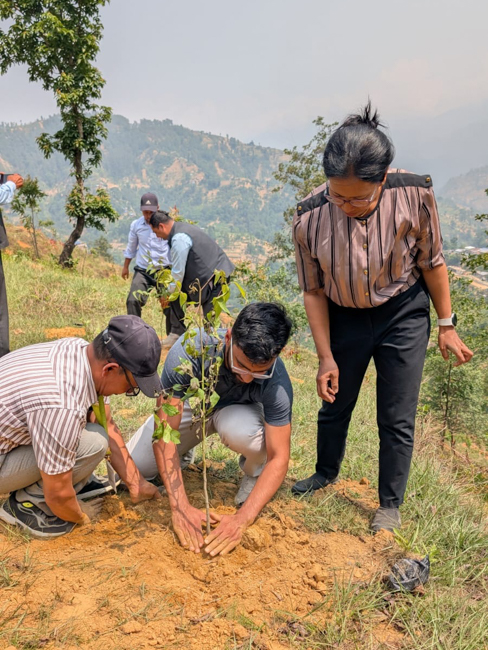 Rockib helps plant a tree during an immersion trip.