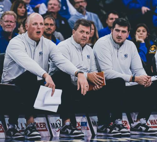Three coaches on the sidelines