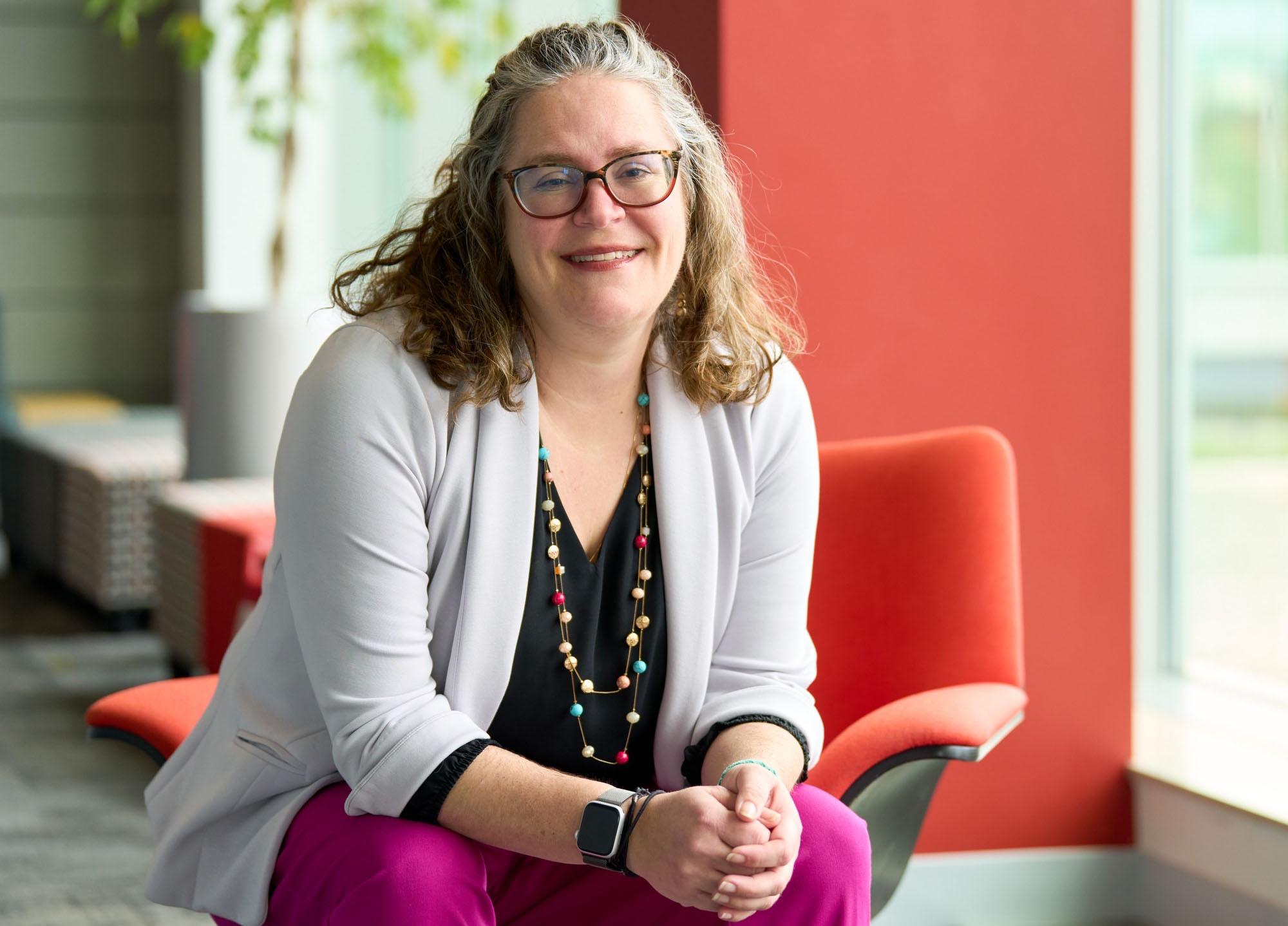 A woman sits and smiles