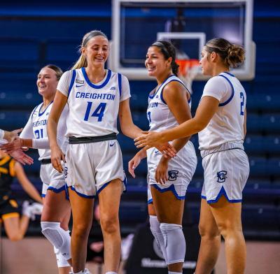 Women's basketball players celebrate after a play on the court