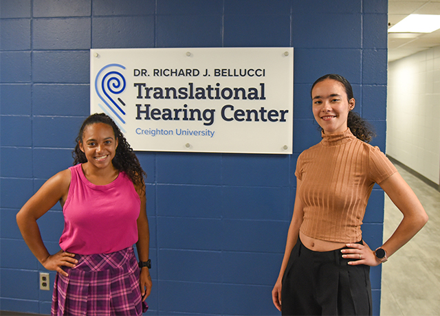 Kalia and Trinity pictures in front of the Bellucci Center sign.