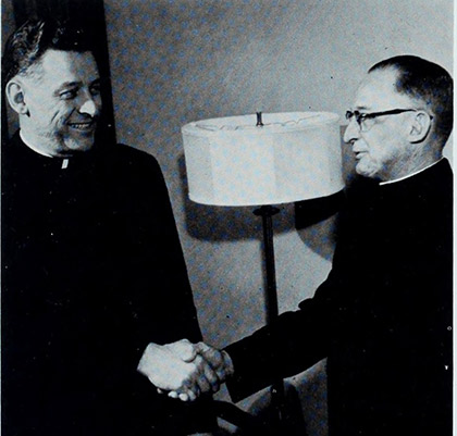 Fr. Reinert and Fr. Linn shaking hands.
