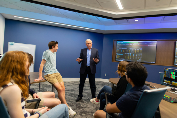 Professor speaks with students in HCOB classroom.