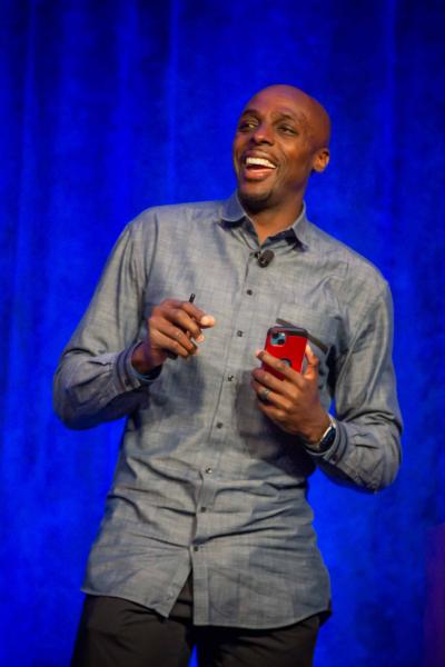 A smiling man speaks on stage
