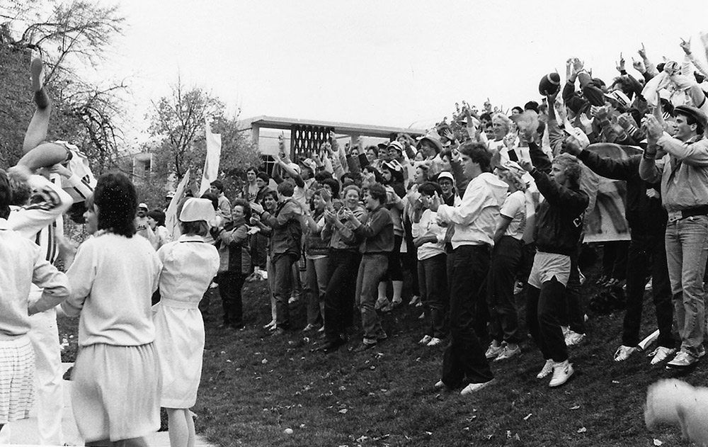 A crowd cheers on the 1983 football team.