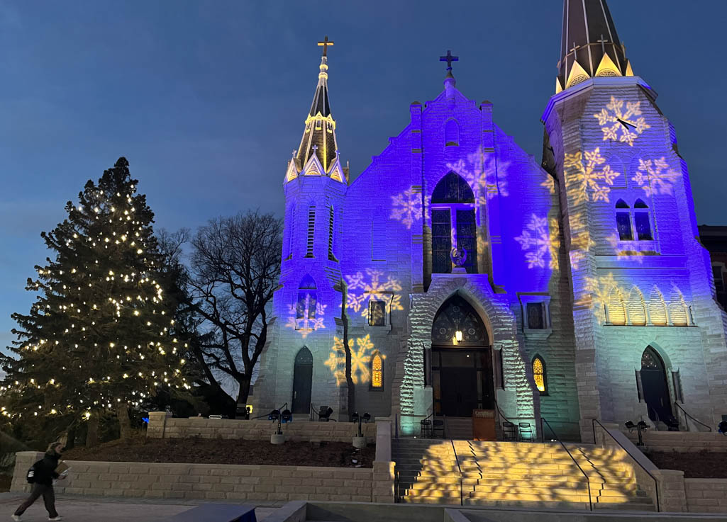 Blue and white festive spotlights shine on St. John's Church