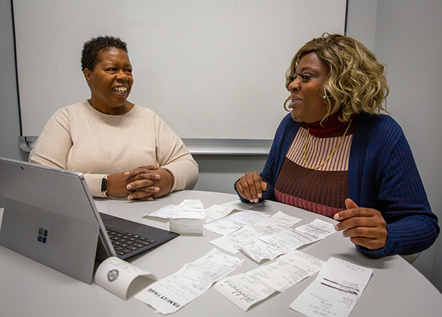 Carmen Bradley, left, a program supervisor with the Financial Success Program, meets with Brieann Clark as part of the Cura Project’s financial success component.