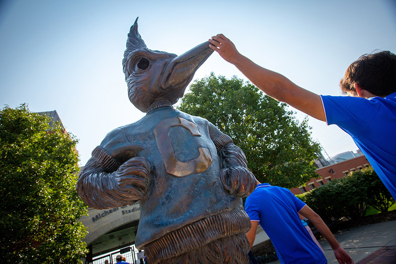 A student taps Billy's beak along the Mall for Welcome Week.
