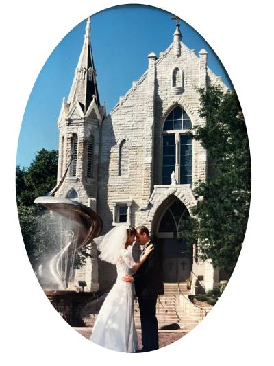 A married couple poses in front of a church