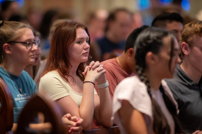 A student prays at Mass.