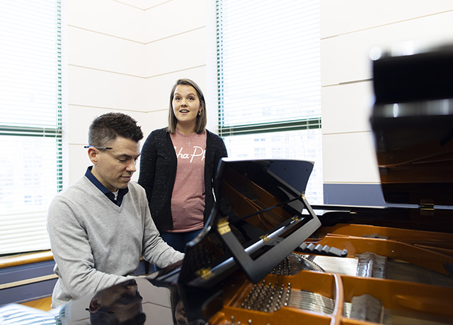 Maggie Brueck sings at a piano.