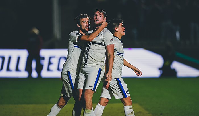 Creighton soccer players embrace after winning a match