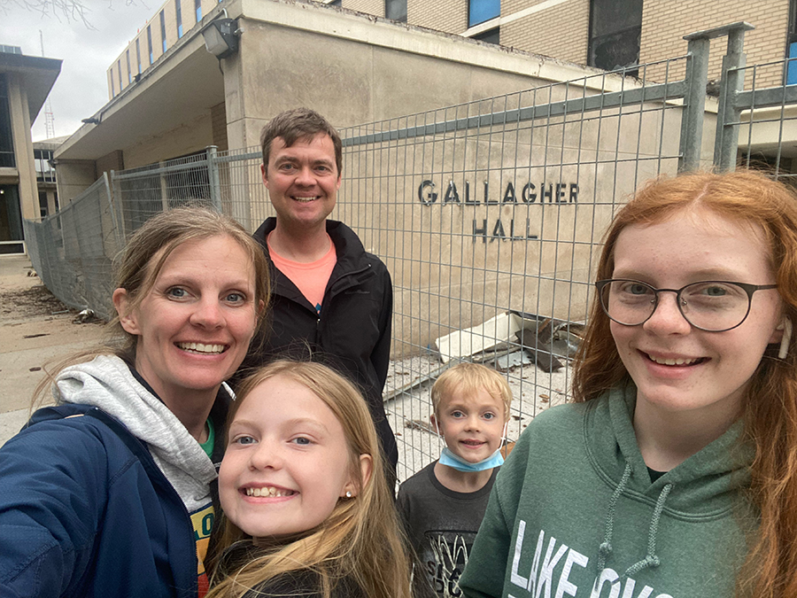 ​  Kent and Elizabeth with their children in front of Gallagher Hall.