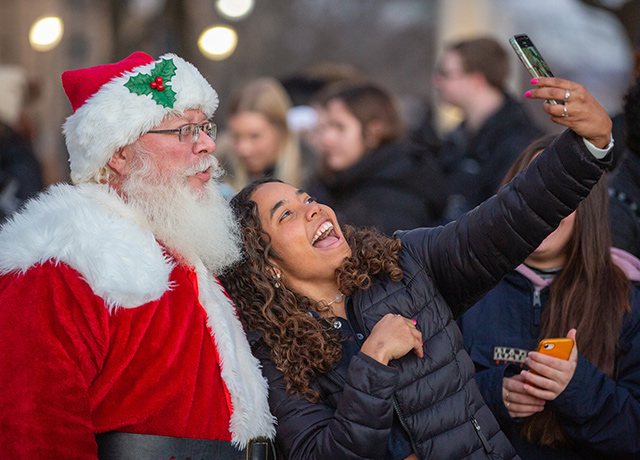 An image takes a selfie with Santa at the Christmas at Creighton celebration.