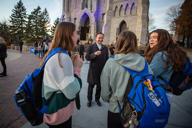 Fr. Hendrickson speaks with students at the Celebration of Light ceremony.
