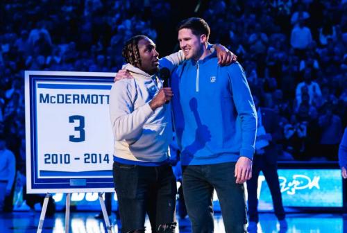 Jahenns Manigat stands with his arm around Doug McDermott during a jersey retirement ceremony