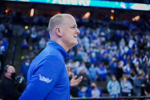 MBB Offseason 2025 Huss II A basketball coach smiles before tipoff