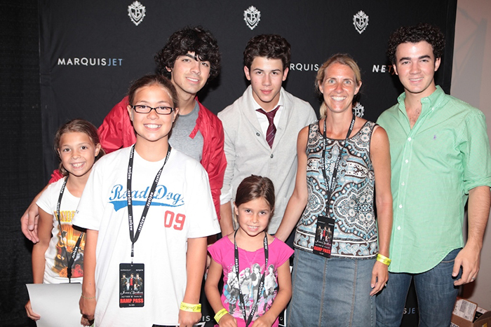 Jonas Brothers posing with mother and children