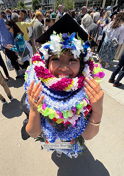 Miranda Burigsay wearing many leis at commencement
