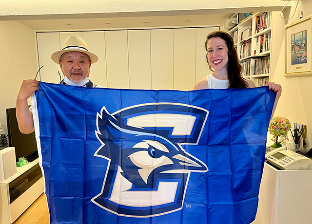 Takanori Korematsu and Lucy Hancock pose with the Creighton flag.