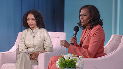 Michelle Obama and the moderator on stage.