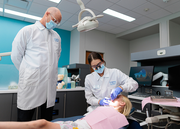 Dr. Bryan Skar oversees a dental student as she treats a pediatric patient in the School of Dentistry's pediatric clinic.