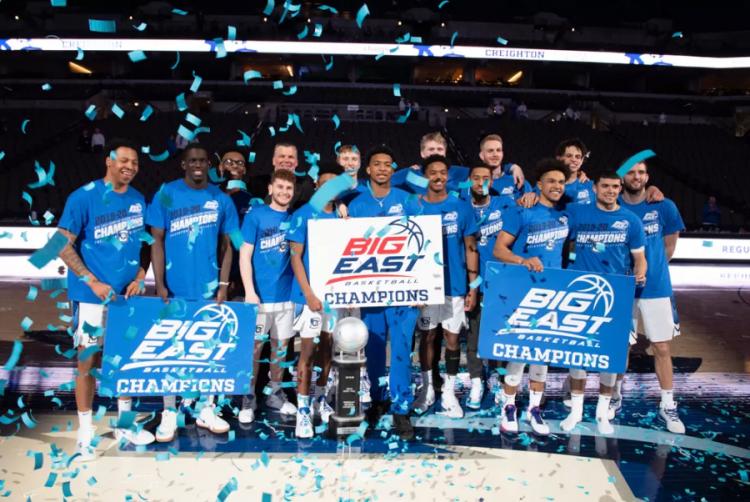 A basketball team stands together for a photo after winning a championship