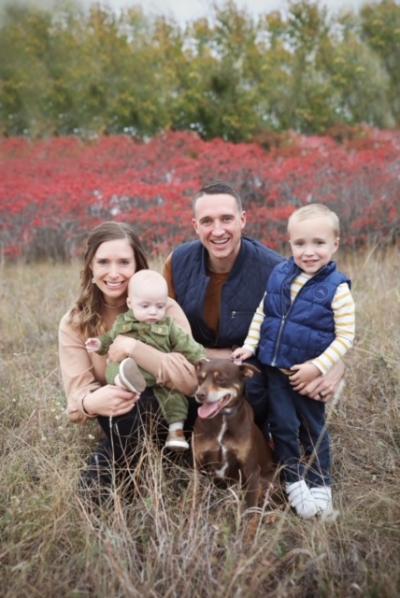 A family of four and their dog pose together for a photo