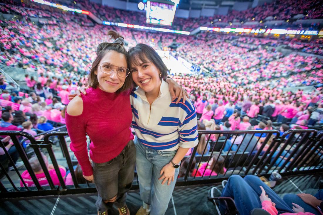 ​​​​Emily and Christen embrace at the Pink Out game at CHI Arena.