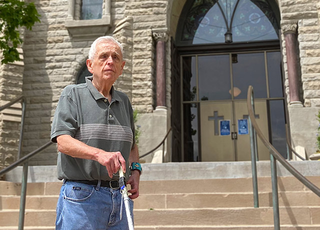 Father Larry Gillick walking in front of St. John's Church.
