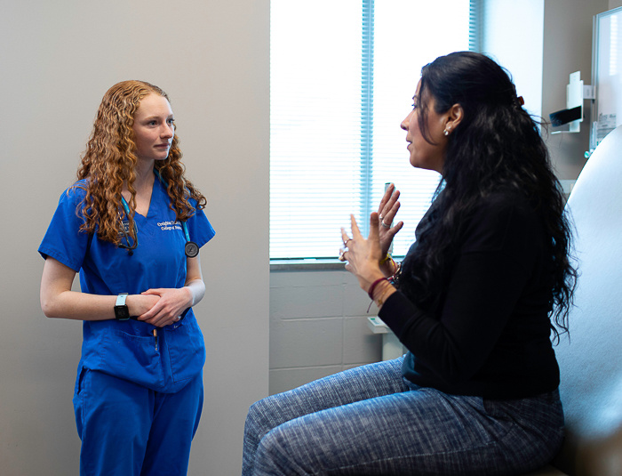 A nursing student interacts with a patient. A nursing student interacts with a patient.
