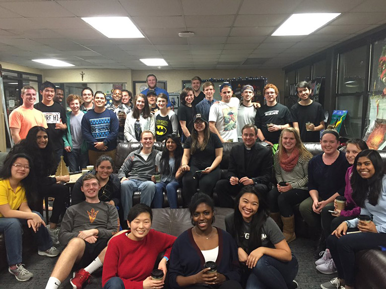 Fr. Hendrickson and students in the lobby of Gallagher Hall.