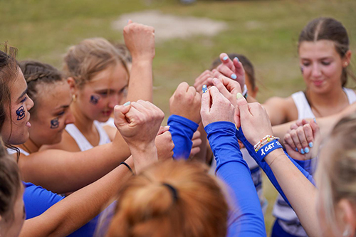 Runners bump hands before a run.