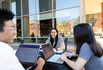 Students sit and talk outside the Highlander