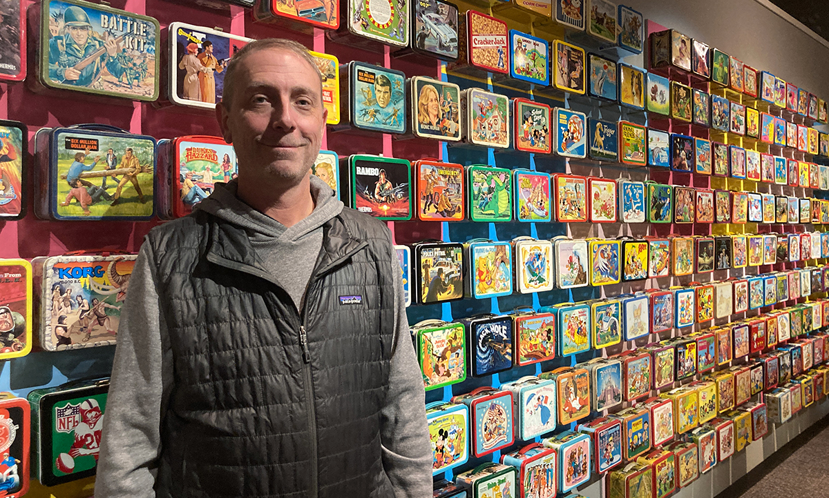 Mark Kelehan pictured in front of a bunch of lunchboxes at his Durham exhibit.