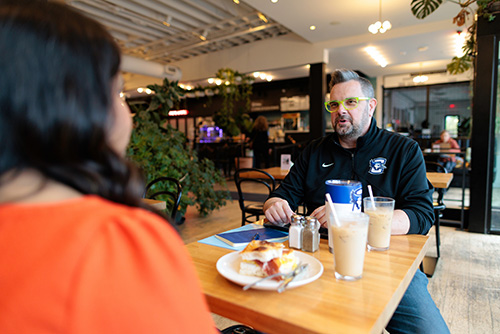 Creighton alum mentoring student in coffee shop Creighton alum mentoring student in coffee shop