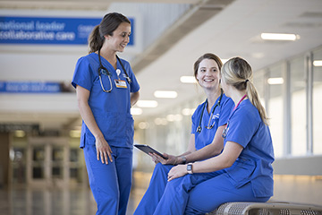 Three Creighton nurses talking at a clinic.