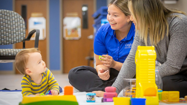 Health sciences student works with a boy and his mother.