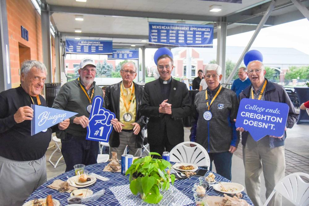 Alumni pose with a college president