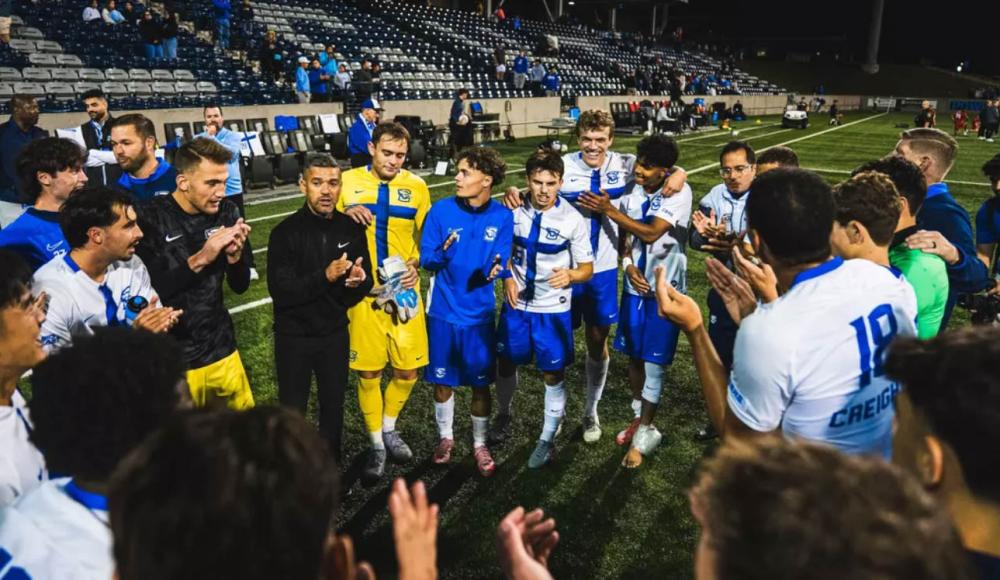 A soccer team huddles after a game