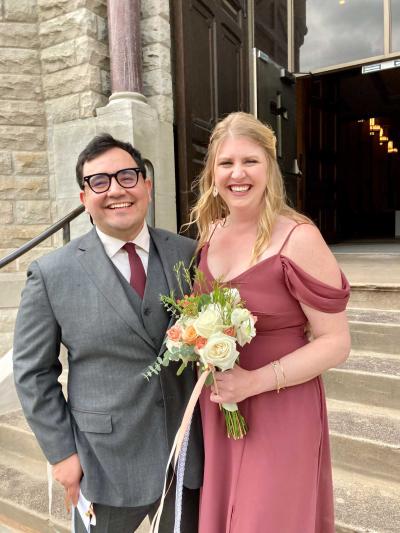 A man and a woman stand together on the steps outside a church