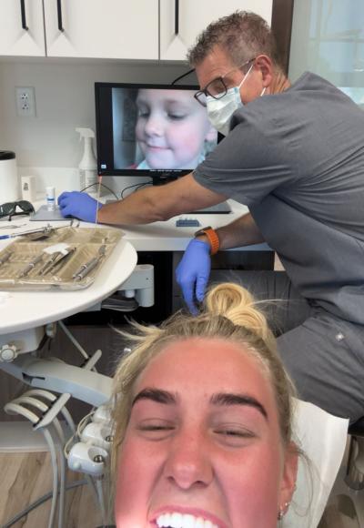 A dentist examines his daughters