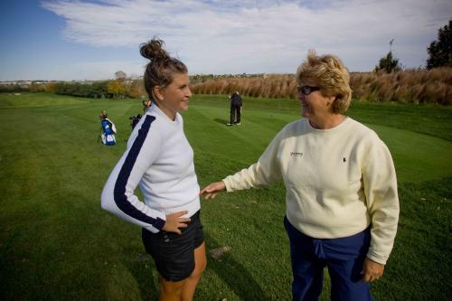 A golf coach talks with a student athlete